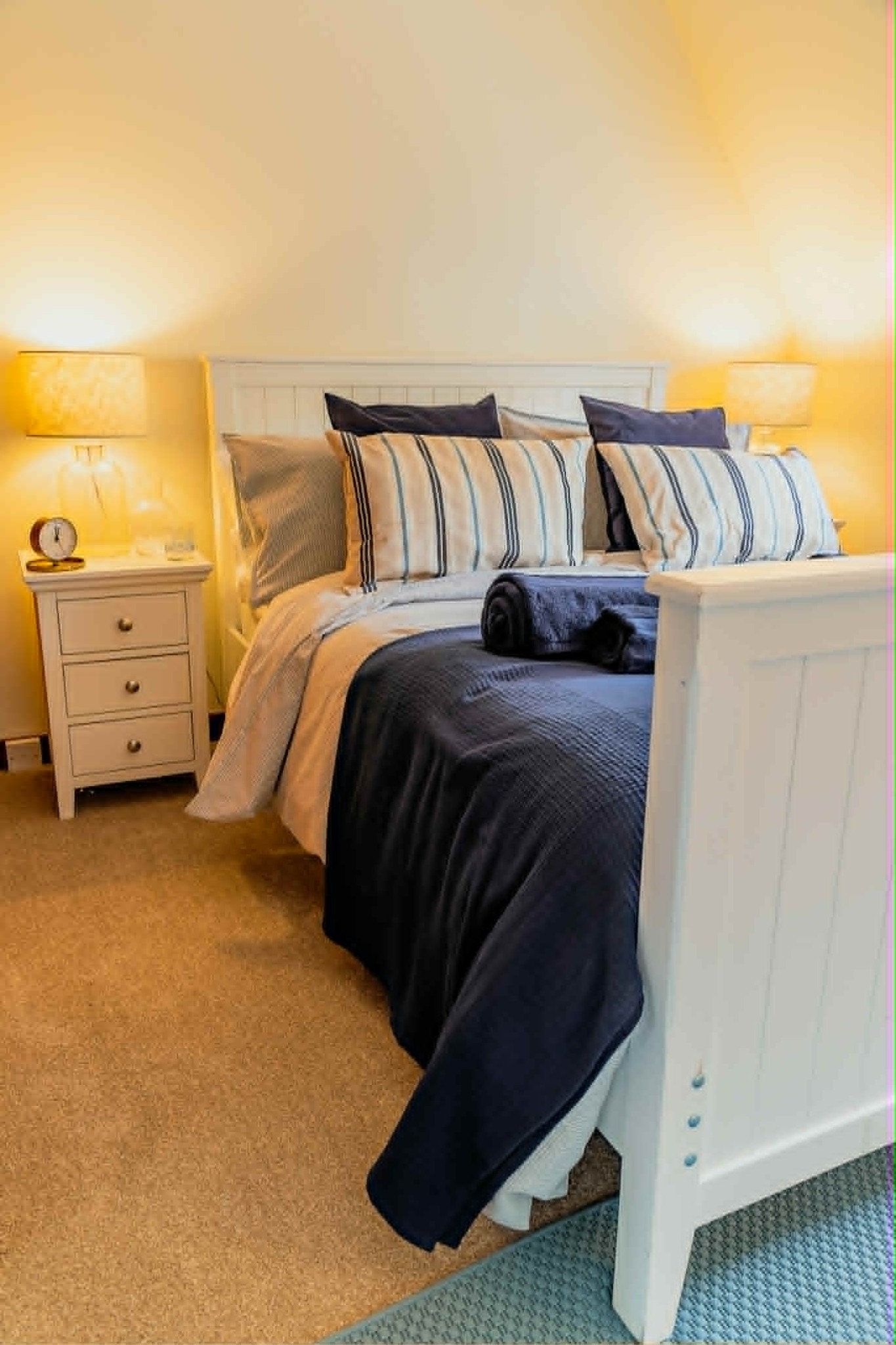 Double bedroom dressed in white and deep blue linen